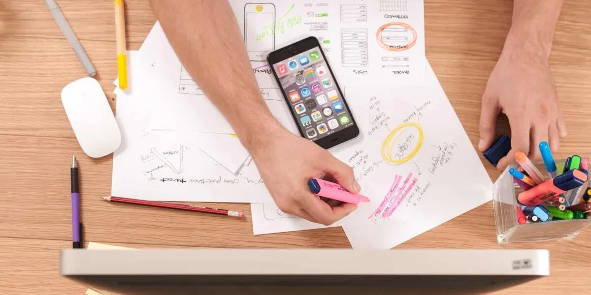 a person sitting at a desk writing keyword ideas on paper