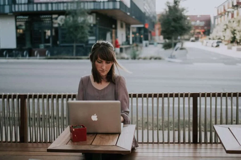 a woman sitting by a computer posting a new blog