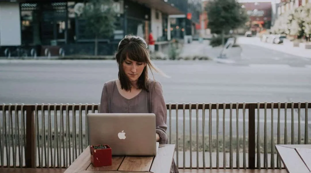 a woman sitting by a computer posting a new blog